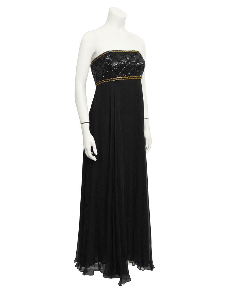 Stunningly beautiful black strapless 1990's empire waist Chanel gown. Black sequins across the bodice are applied in a textured classic Chanel diamond quilt  pattern. The bodice is trimmed in black and gold beading to replicate gold chain. The back