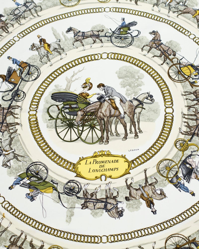 Beautiful and classic Hermes large silk scarf with an equestrian theme of horses and carriages. Originally issued on 1965 by Phillipe Ledoux, has been reissued many times in multiple colors. The deep blue, white and gold in this version contrasts