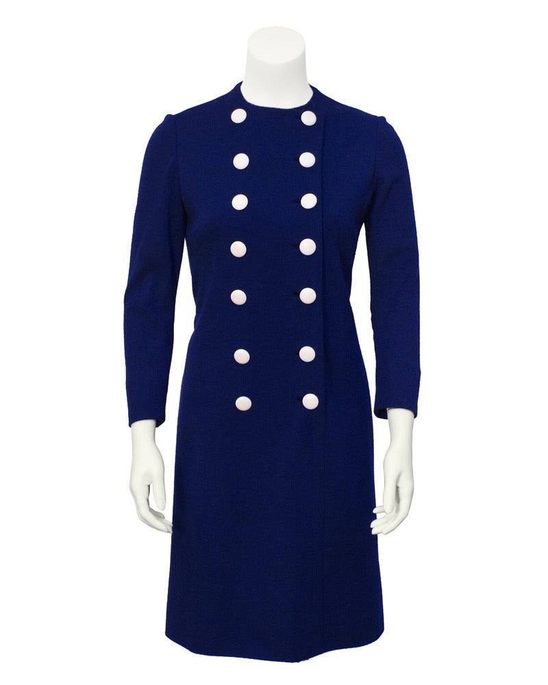 The perfect Norell 1960's long sleeve day dress. Cute as a button, blue wool jersey, double breasted white buttons and white cotton pique detachable collar and cuffs. One dress, two looks spring fresh/fall winter. Blue fabric belt ties at natural