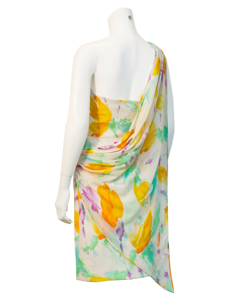 Ungaro circa 1980's pastel floral cocktail dress. Hand painted look to the delicate pattern over white chiffon. Elegant draped fabric over one shoulder. In excellent condition and a very good example of the feminine styling that Ungaro was best