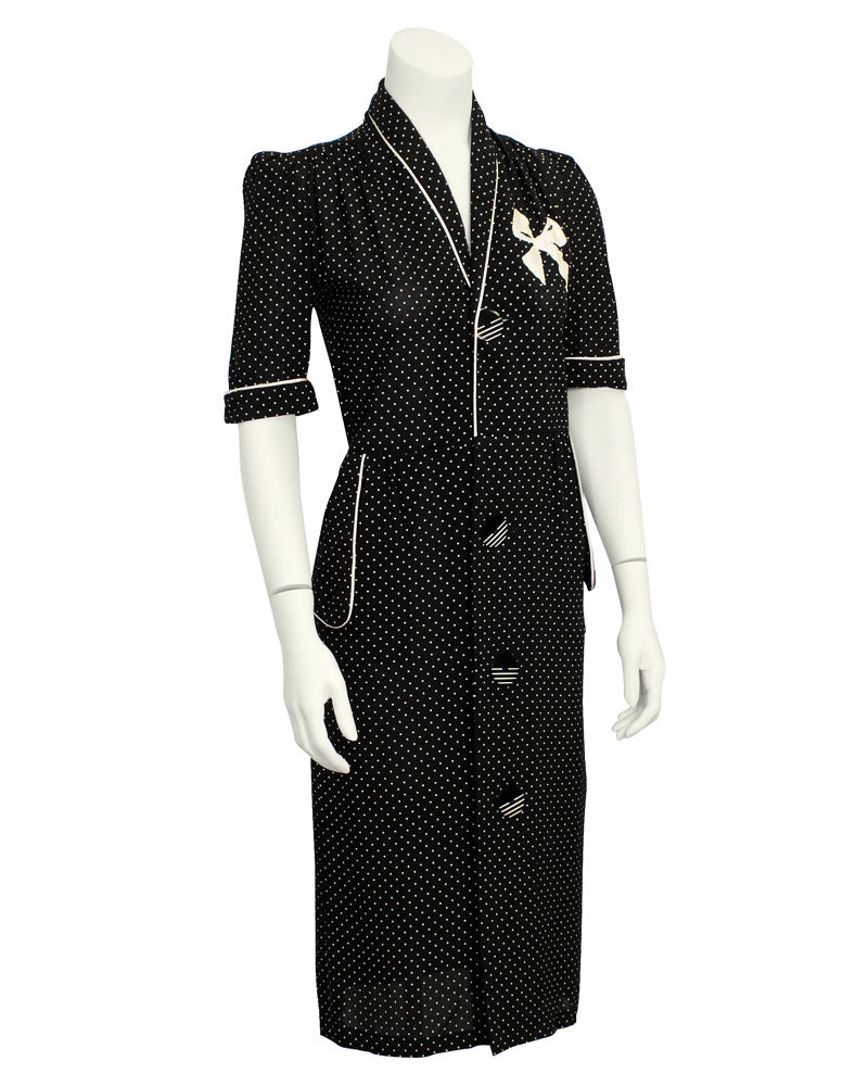 Early 1970's acetate and nylon blend button front shirt dress from London store Bus Top by Lee Bender. Black with tiny white polka dots and white piping at collar, sleeves and pockets. Fabulous oversized buttons that have a solid top half and a