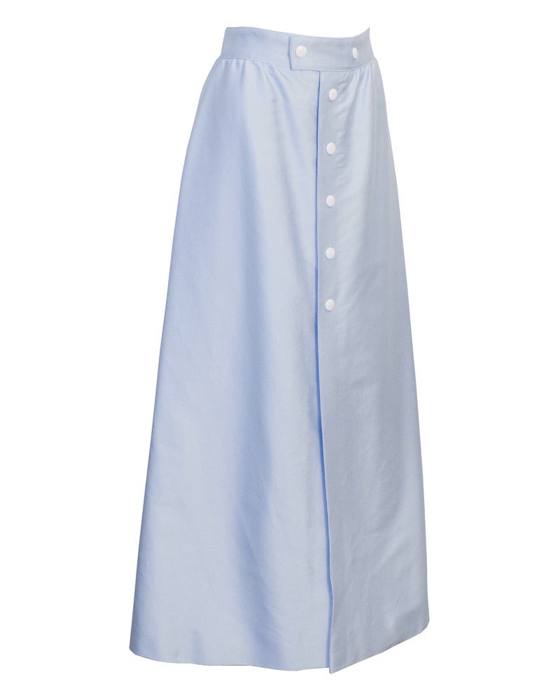 Late 1960's baby blue 100% cotton a-line midi skirt. Skirt wraps around body fastening with contrasting white snap buttons at waist and down the front center seam. Great, versatile piece. Very slight discoloration in fabric near the bottom at the