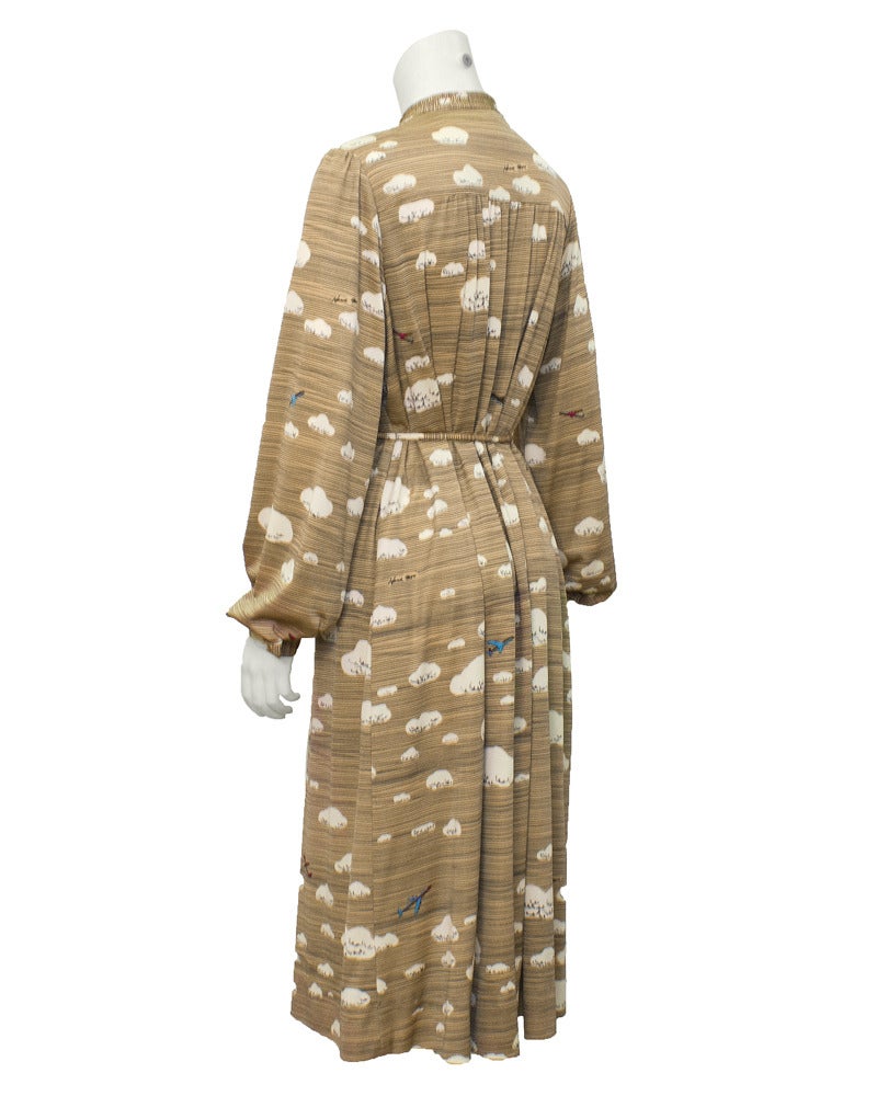 From Hanae Mori, the first Asian label to be considered Haute Couture, a 1970's sky printed jersey blend dress with airplane buttons and matching belt. The taupe colored dress features an all over pattern of clouds and airplanes with exquisite snap