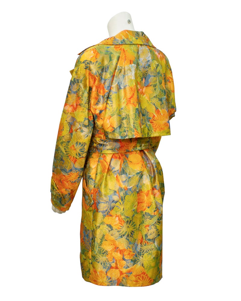 Flowers are in bloom on this Adele Simpson 1970's evening trench. Brocade fabric with gold highlights, dressy rhinestone double breasted closure offers the high style of daywear with the elegance of evening. In excellent vintage condition. Turn up