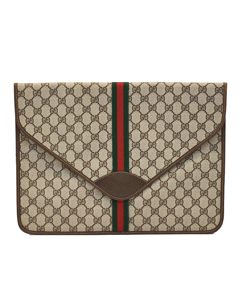 Stunning 1970's Gucci portfolio case. The portfolio is covered in the classic logo Gucci monogram with the Gucci green and red woven tape stripe down the front. Trimmed and lined in brown leather. Gold Gucci stamp on inside. Perfectly fits a 13
