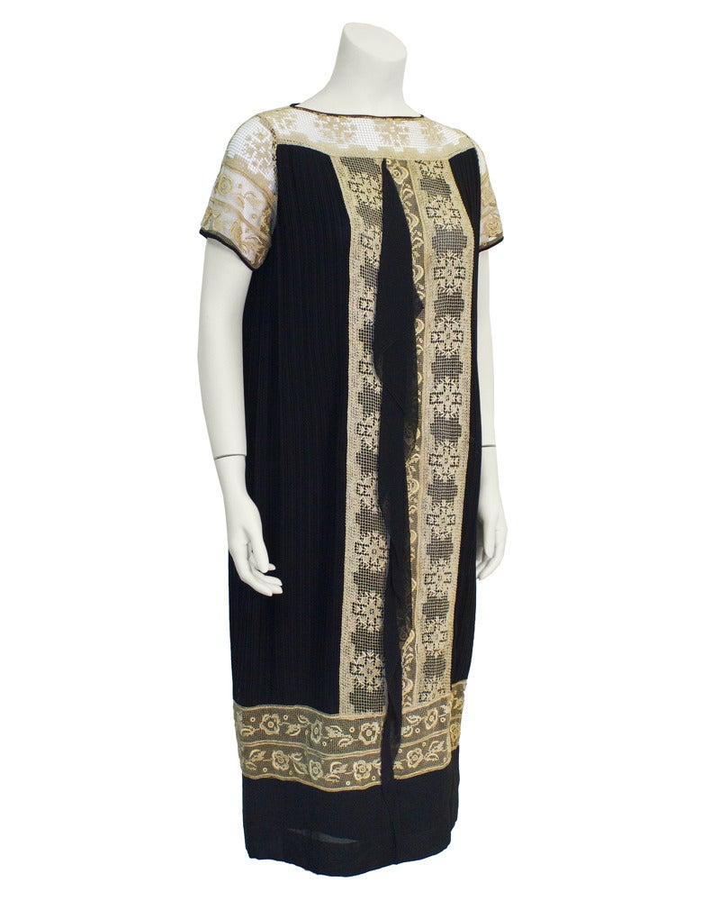 1930's black micro pleated flapper dress. Decolletage features stunning and interesting beige lace with black trim. The lace continues vertically down the dress and is also featured horizontally around the bottom of the dress. Further details