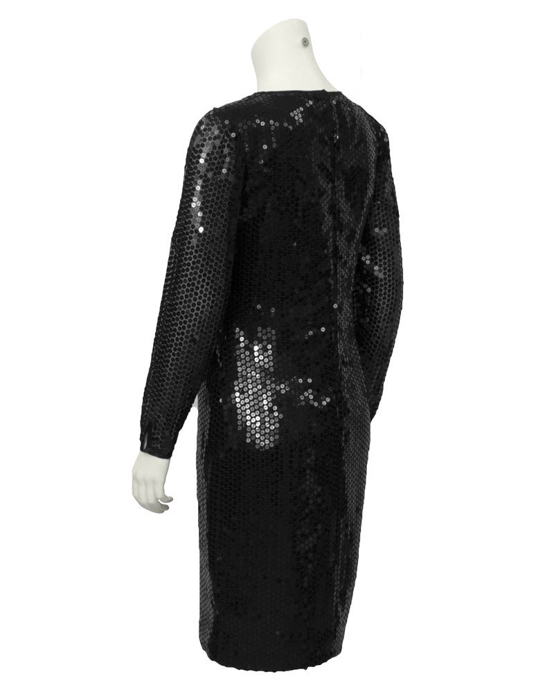 1980's Bellville Sassoon black long sleeve sequin cocktail dress. Sleeves are left unlined and sheer to add sex appeal. Crew neck and invisible zipper up the back. Timeless and flattering cocktail look.