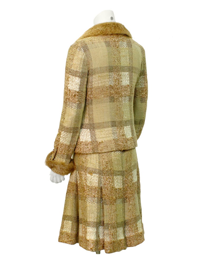 Chanel Couture fur trimmed suit from the 1970's. Subtle beige & cream hand woven plaid jacket and skirt. Fitted silhouette with China mink trim on collar and cuffs. Soft flare to loose box pleat top stitched skirt. Clear plastic domed buttons with