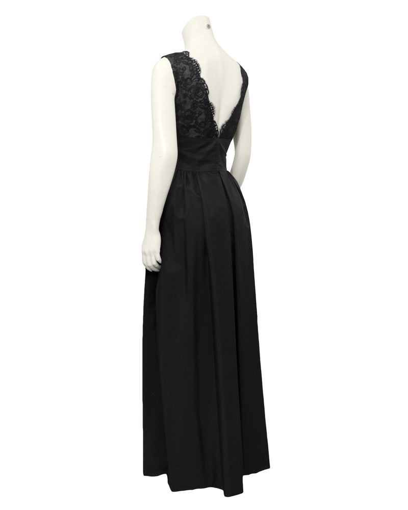 A beautiful 1960's delicate black lace and silk gown by Helen Rose. Scallop edged lace along the v neckline in the front and back. Bandage fitted waist with loosely gathered semi full shape skirt. Side seam pockets. In excellent vintage condition.