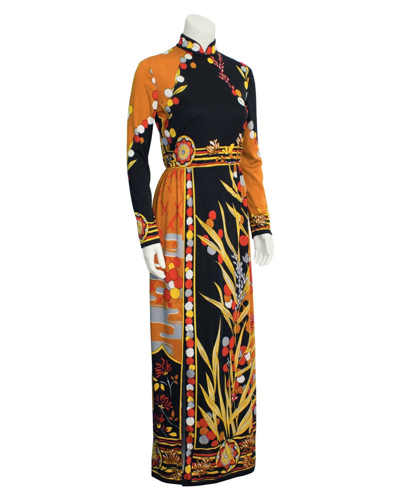 Absolutely stunning long sleeve, mandarin collar 1970's Paganne gown. Simply styled true waist silhouette made from polyester jersey fabric featuring an abstract plant print in tan, yellow, black, red, white and grey. Elastic at waist. Small slit up