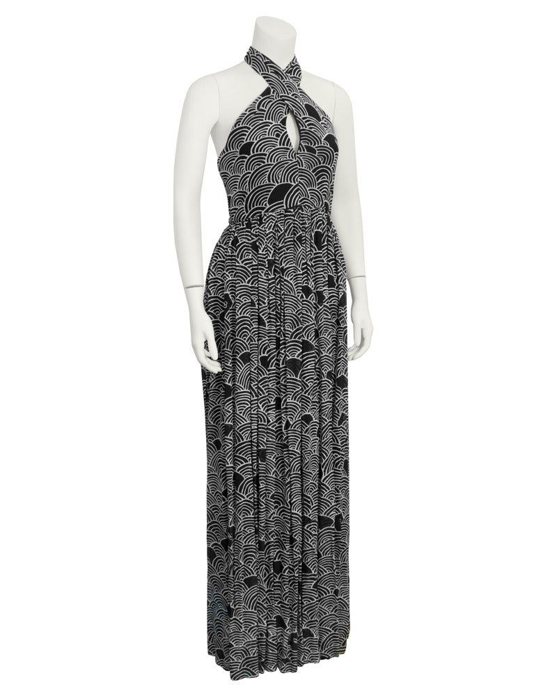 Stunning Geoffrey Beene Boutique gown dating from the 1970s. Cut from black and white printed fabric, the gown features a cross over halter neckline that fastens with snaps at nape of neck, a fitted bodice and a flowing loose gathered skirt. Small