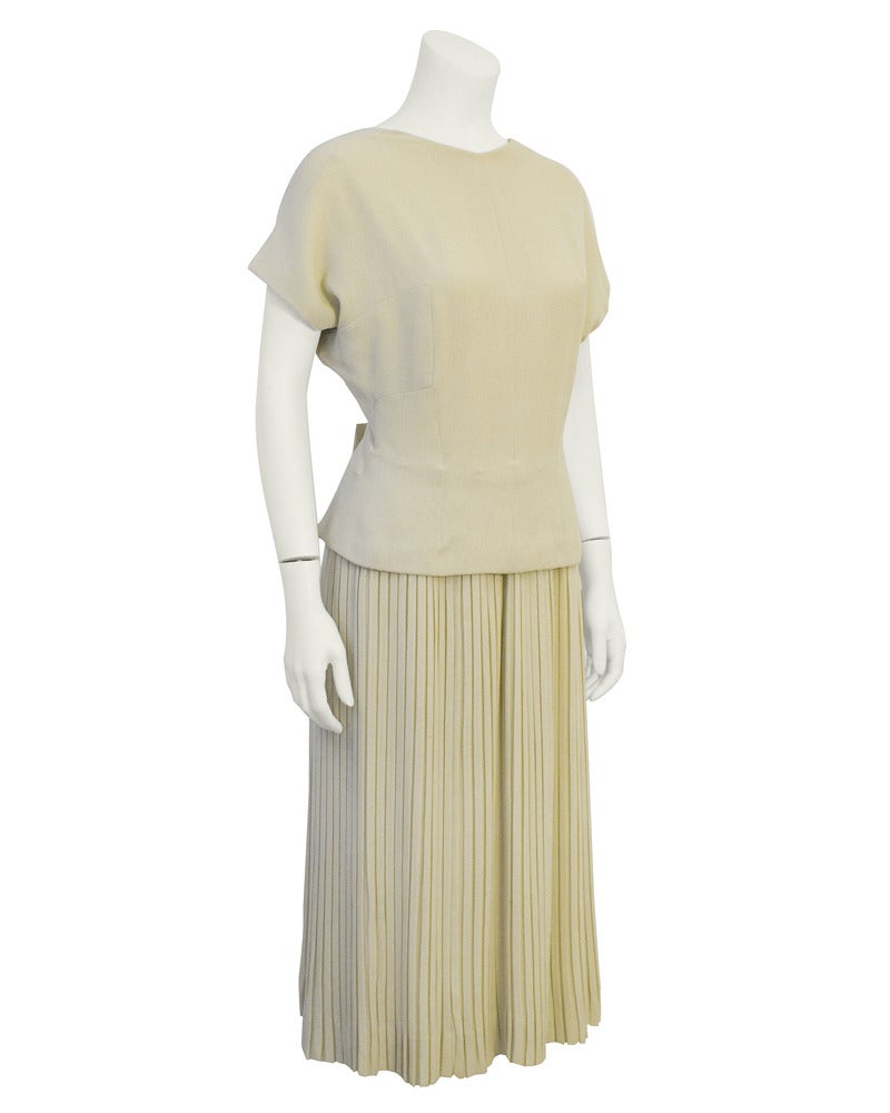 1940's Lucile Manguin Haute Couture silk crepe dress. Domed shoulders, fitted waist, micro pleated skirt, low scoop back and bow detail on the waist at the back center seam. All the features of a haute couture piece including the hand printed style