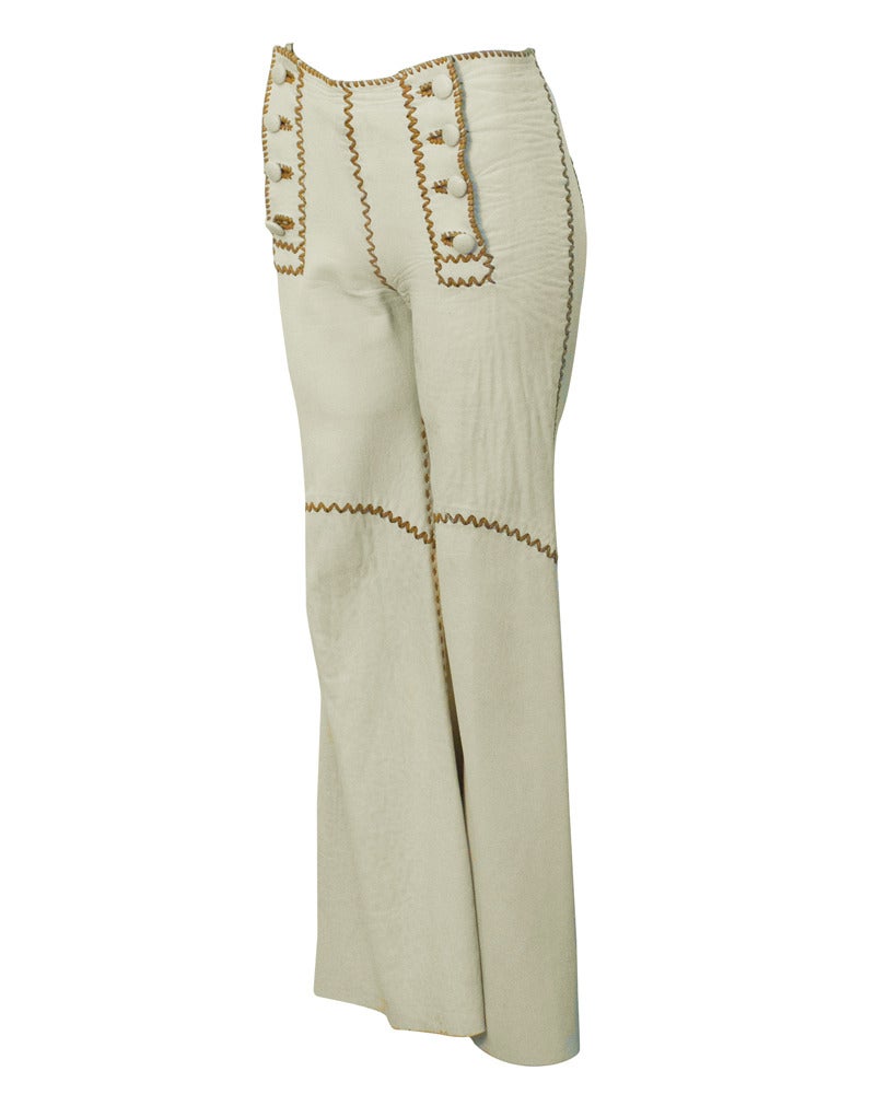 The perfect early 1970s rock 'n' roll pants. Natural  chamoix leather flared bell bottoms with chestnut brown whip stitching up all the seams and around the double set of matching leather covered buttons. Sailor front button fit. Blind stamped NBL