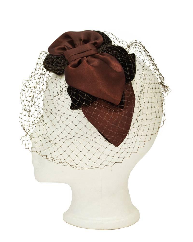 Elegant 1950's brown velvet and satin bow shaped fascinator/evening hat. Matching brown netting across the face. Excellent vintage condition. 
 