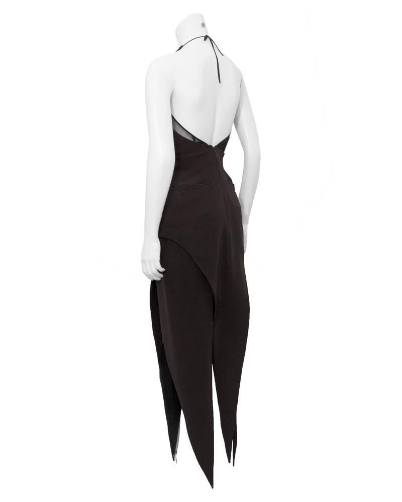 This Karl Lagerfeld 1980's piece is over-the-top sexy. Sheer inserts along the v-neck of the halter, long hanky point style hem accented with sheer edging and a plunging back. Black finely corded silk. Very good vintage condition, slight color