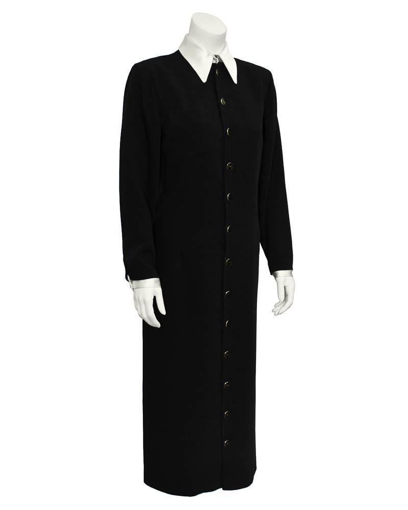 1980's Yves Saint Laurent black poly/gabardine button front shirt dress. Contrasting exaggerated white collar and cuffs. Amazing and collectible YSL logo buttons. Excellent vintage condition. Fits like a 6-8 US.