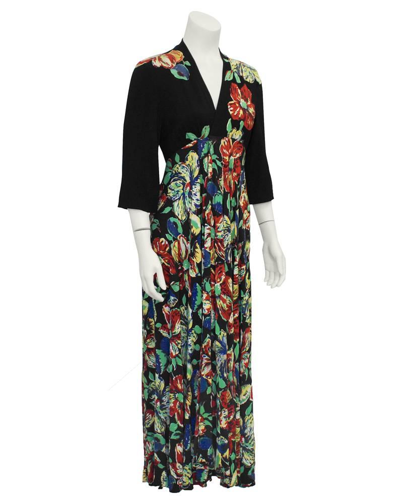 1960's Linda Kinoshita, New York designer at the time of Ossie Clark, Biba, Thea Porter, moss crepe black long sleeve maxi dress. Deep v neck, beautiful all over floral print with sewn appliques on bodice in vibrant tones of red, green and blue.