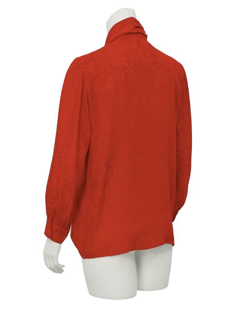 1980's Yves Saint Laurent red silk jacquard shirt with bows throughout. Quarter zip front with neck tie which can be styled to your personal liking. Excellent vintage condition. Fits like a US 4-6.