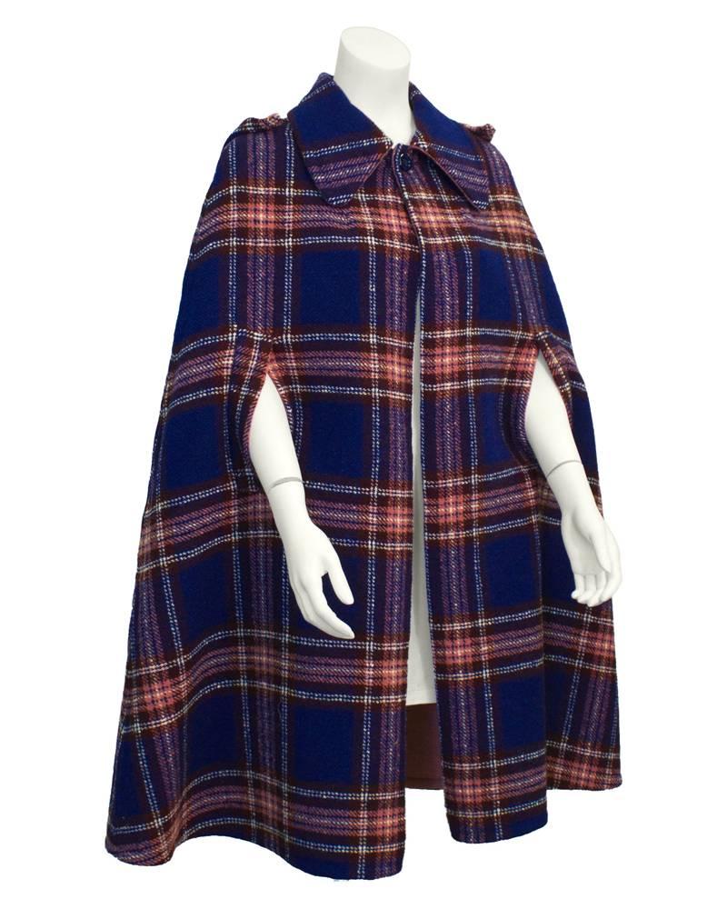 1960's blue, rose, white and brown plaid wool A-line cape. Single-button closure at neck, exaggerated collar with detachable hood. Rose wool lining. Excellent vintage condition. Generous fit, works well from US 6-10.