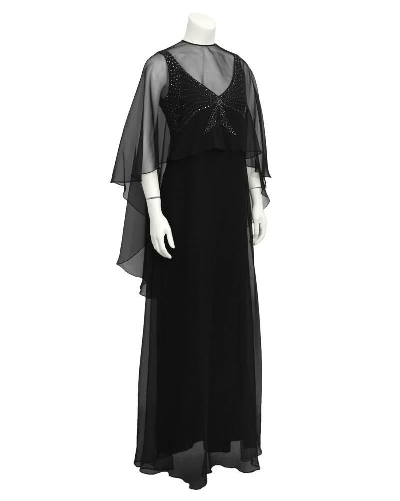 Elegant 1973 Leo Narducci black sleeveless V-neck chiffon gown with rhinestone studded bodice and matching removable high-low diaphanous caplet. Perfect for an evening that requires a touch more 