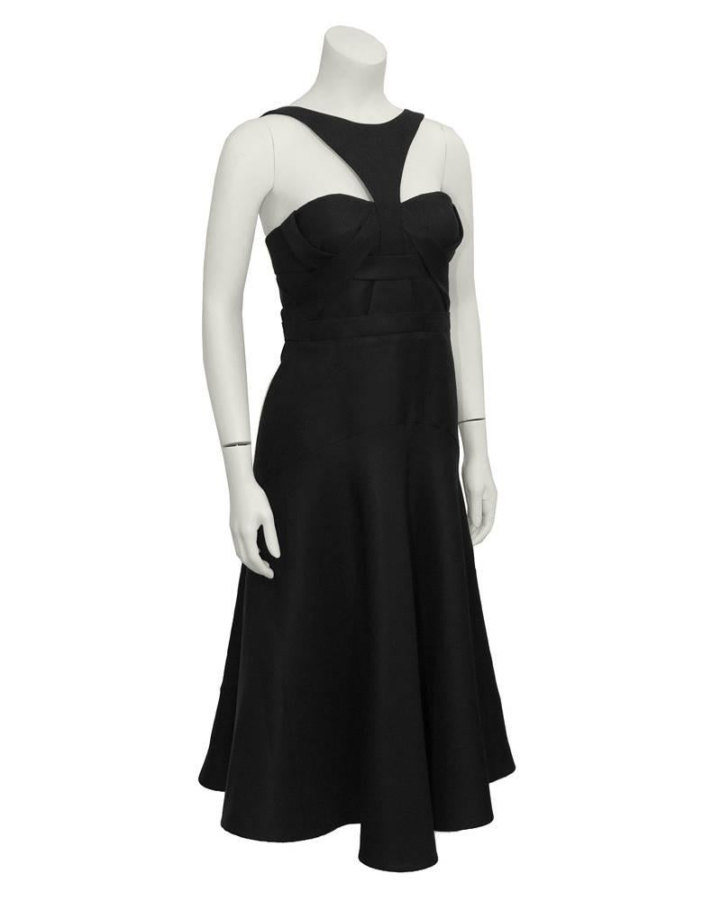 This J Mendel recent collection black cutout cocktail dress mixes sophistication with sexy, featuring a bra top half and flared mid-length skirt bottom. Interwoven fabric on bodice. Cutout on back with a back zip closure. Excellent condition. Fits