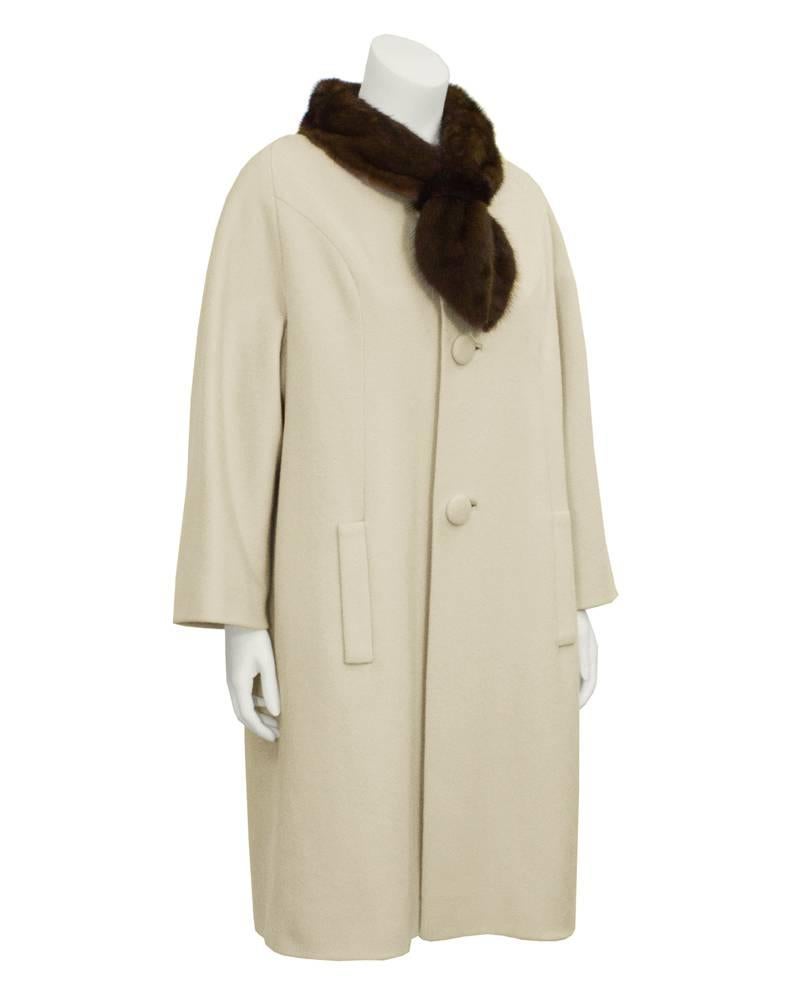 Lovely warm beige Lilli Ann wool coat dating from the 1950's. A-Line shaped with silk lining, an extended mink fur collar, slash pockets and large fabric buttons. Vertical seaming down front, and fixed pleats on back. Excellent vintage condition.