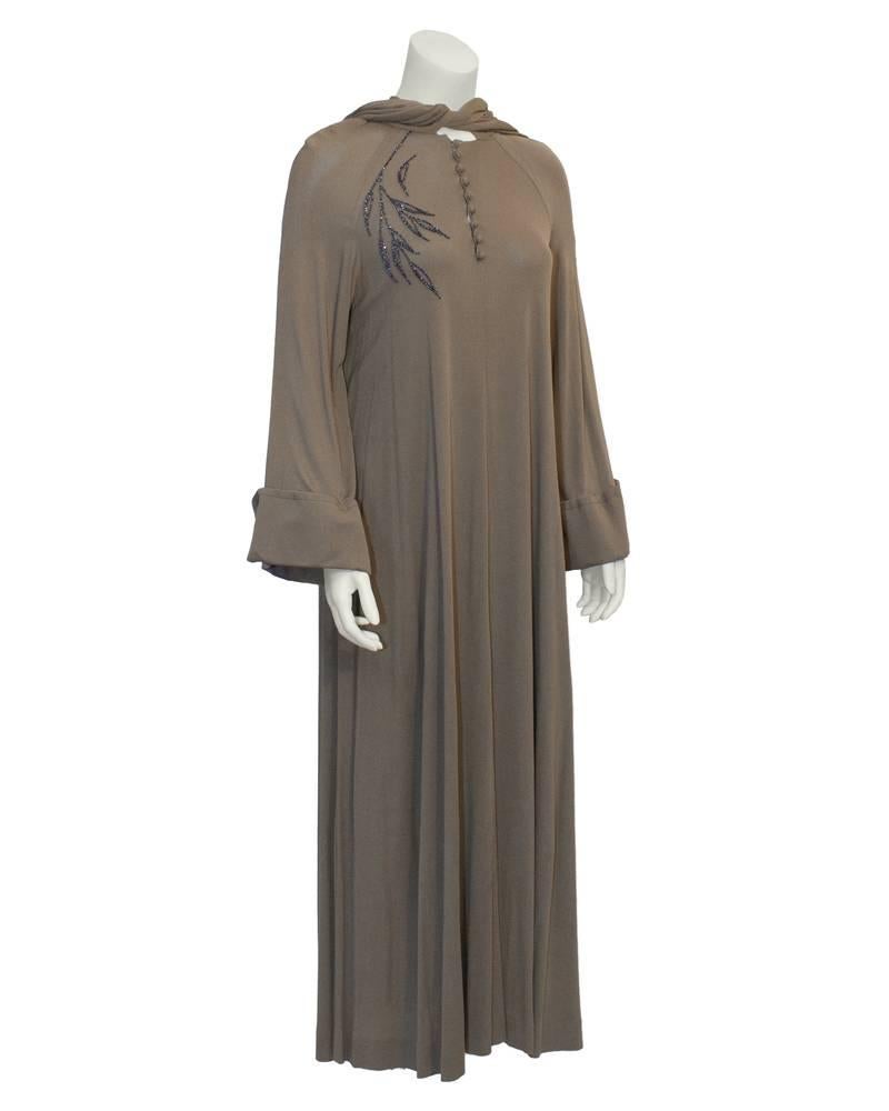 Stunning long-sleeve hooded Vicky Tiel gown from the 1980's. Mocha colored jersey material is draped, with beaded leaf design on the left shoulder. Small loop buttons down bodice. Excellent vintage condition. Generous fit from 4-8 US.