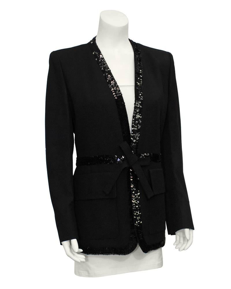 Fabulous Sonia Rykiel black crepe belted robe style evening jacket from the 1980's. The collarless piece is trimmed down the front with a wide band of black sequins and a sequin band around the waist finished with a self tie belt. Two large patch