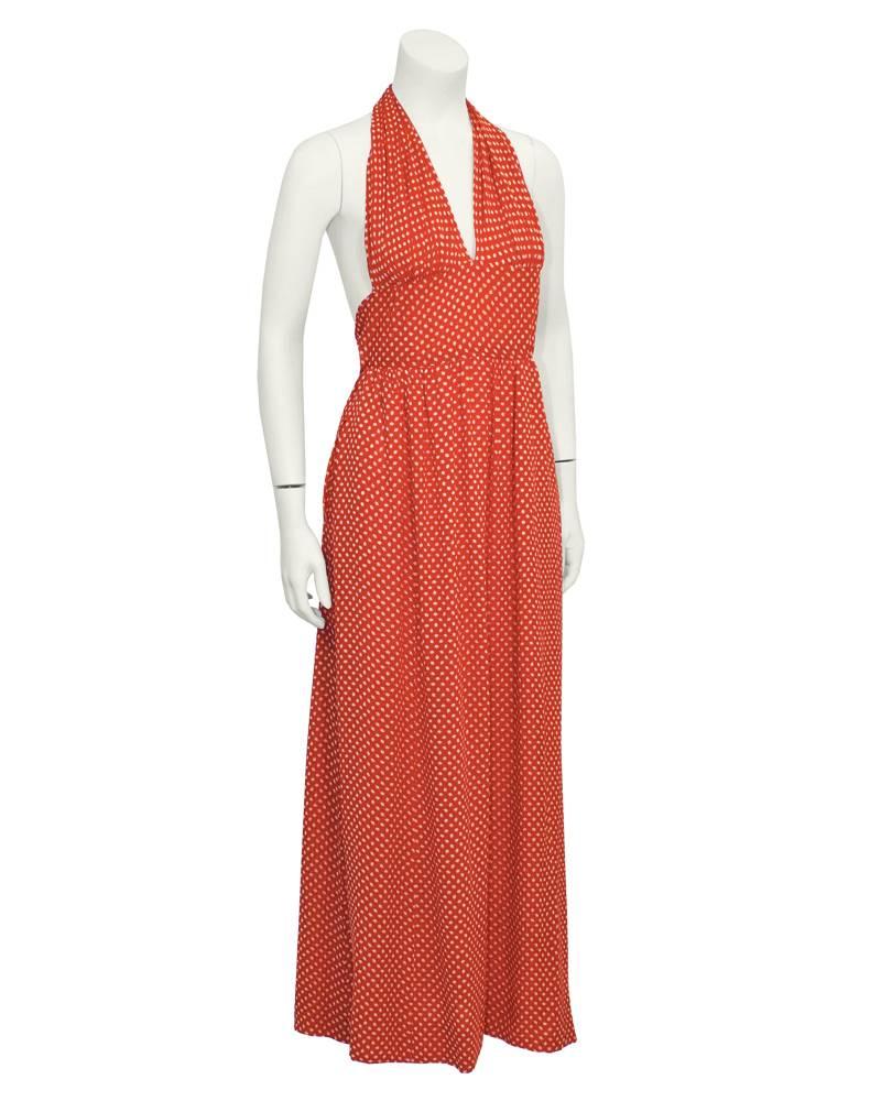 Stunning 1970's red moss crepe Halston halter dress with polka-dot pattern throughout. White dots are in scallop shell shape. Slightly elevated waist is elasticized, and has a long tie which can finish at the back or wrap to the front. Long