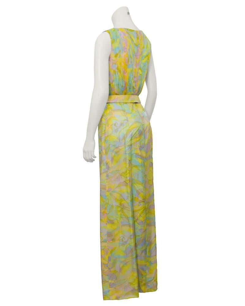 Beautiful and feminine, this pastel printed chiffon day/evening gown by desirable British designer Hardy Amies dates from the 1960's. The fully pleated chiffon bodice fits like the top of a sheath style dress and is sleeveless with a high round