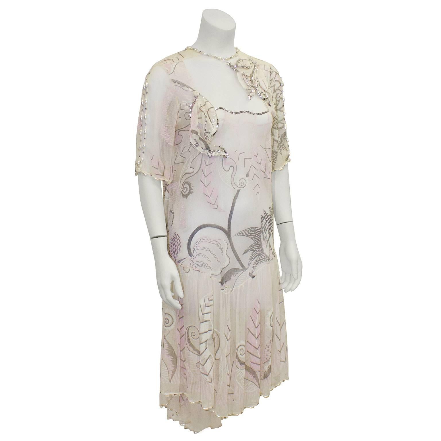 Stunning 1980's Zandra Rhodes light pink and cream hand painted silk chiffon dress. Sheer fabric on the decolletage with short sleeves. Pearl detailing along the neckline, sleeves and hem. Drop waist, with a very low cowl back. Renowned free hand