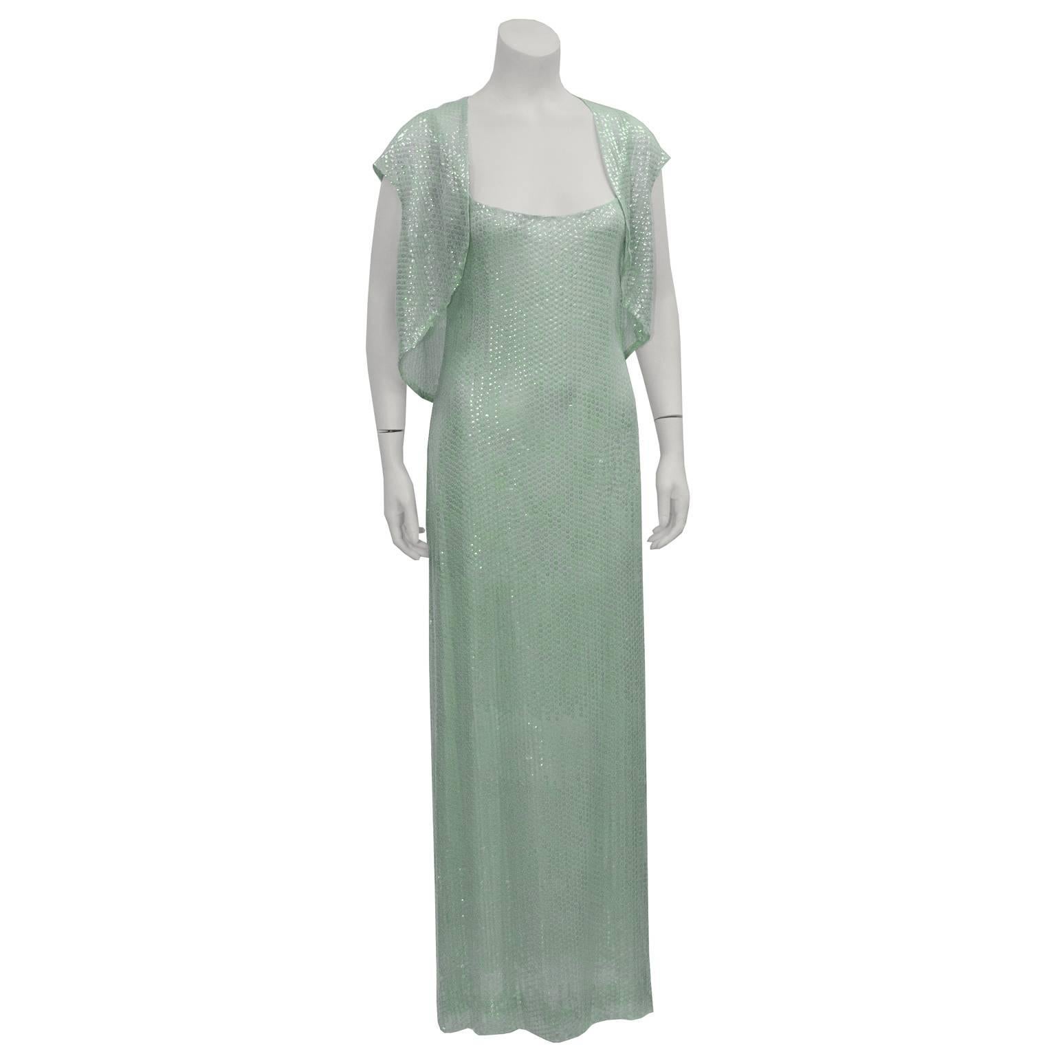 This stunning 1970s Halston gown is mint green silk chiffon covered entirely with iridescent mint sequins. Gown has a sheath silhouette, with a camisole neckline. Fully lined in chiffon. Matching bolero is short sleeved and also entirely covered in