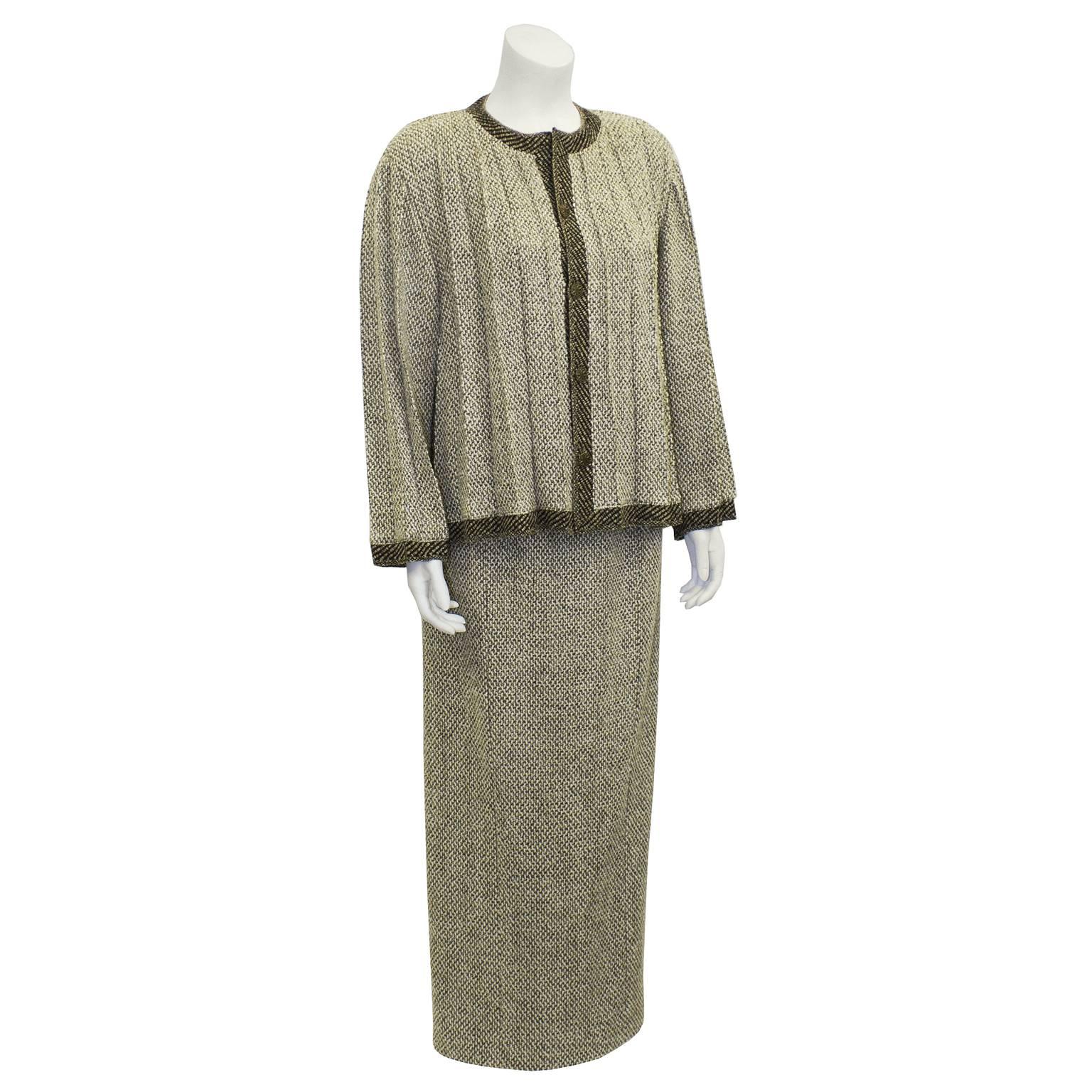 This amazing 1998 Chanel two tone brown tweed skirt suit is a unique set with its pleated swing style jacket and optional rope belt. Jacket is trimmed in a darker brown color and has antiqued bronze buttons wheel motif and CC logo in the center.