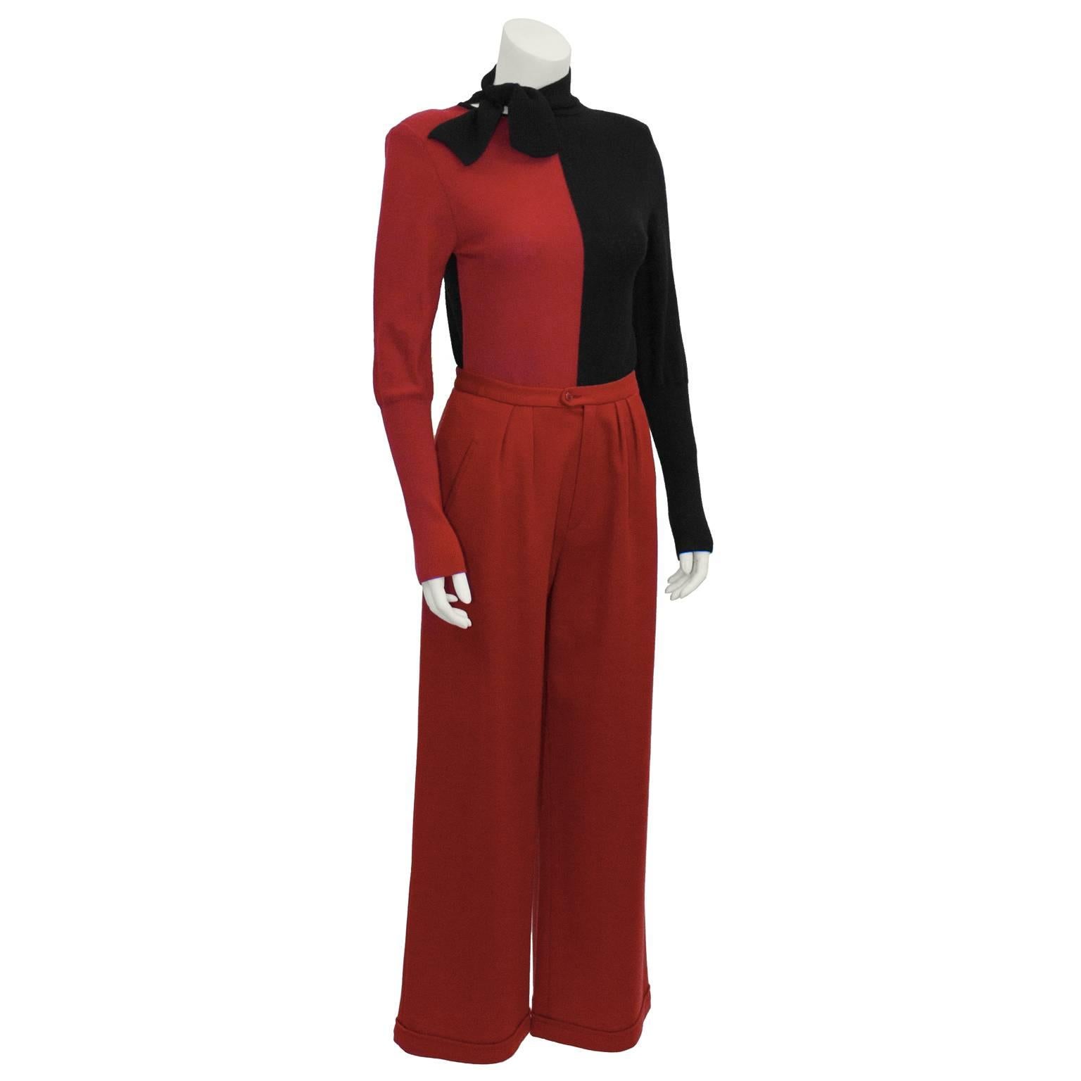 Make a fabulous statement with this Sonia Rykiel raspberry red and black knit ensemble from the 1980s. Color block red and black knit sweater has an off set petite necktie, and long sleeves ribbed to the elbow. Back side is all black. Brilliant