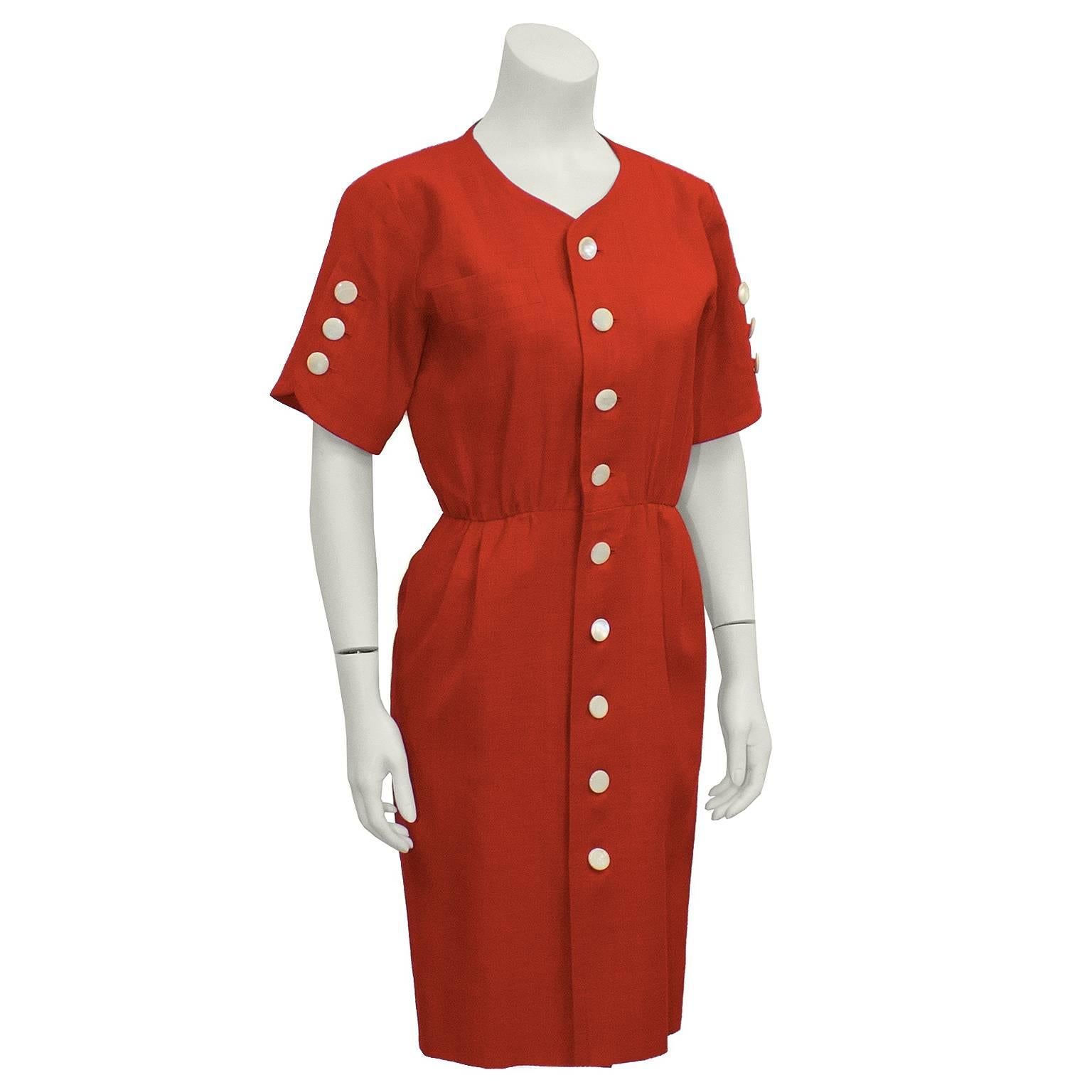 Adorable Yves Saint Laurent red linen dress that dates from the 1980's. Slim cut, with short sleeves and a small flap pocket on right breast. Small pleats around the waist line. Medium plastic white buttons down the front center, and three on each