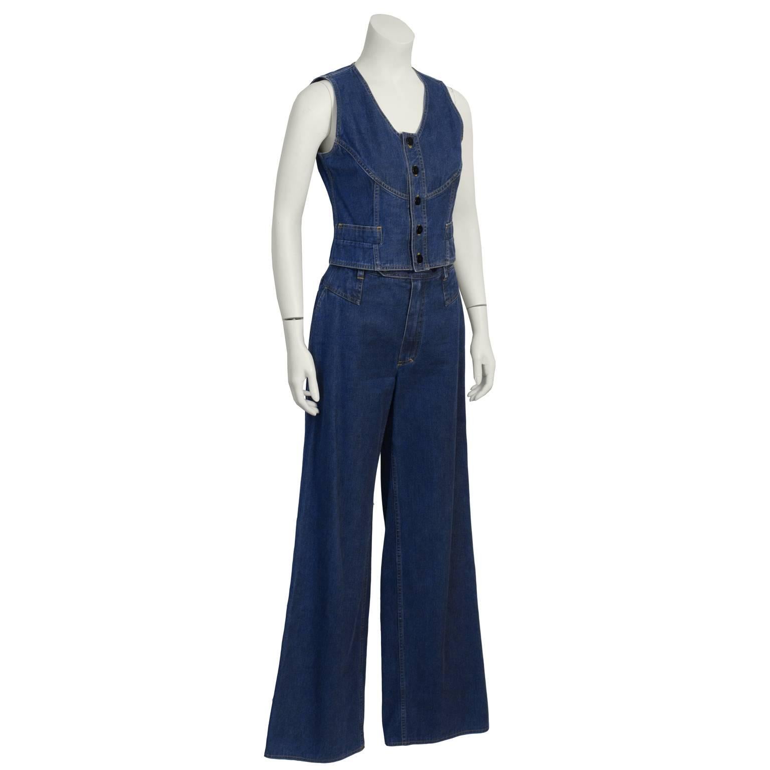 The best Chanel denim set from the early 1990's. Vest is waist length and has a deep V cut. Two flap pockets at the fitted waist. Front button closure, with copper tone metal buttons. Fabulous denim pants are high waisted and wide flared. Excellent