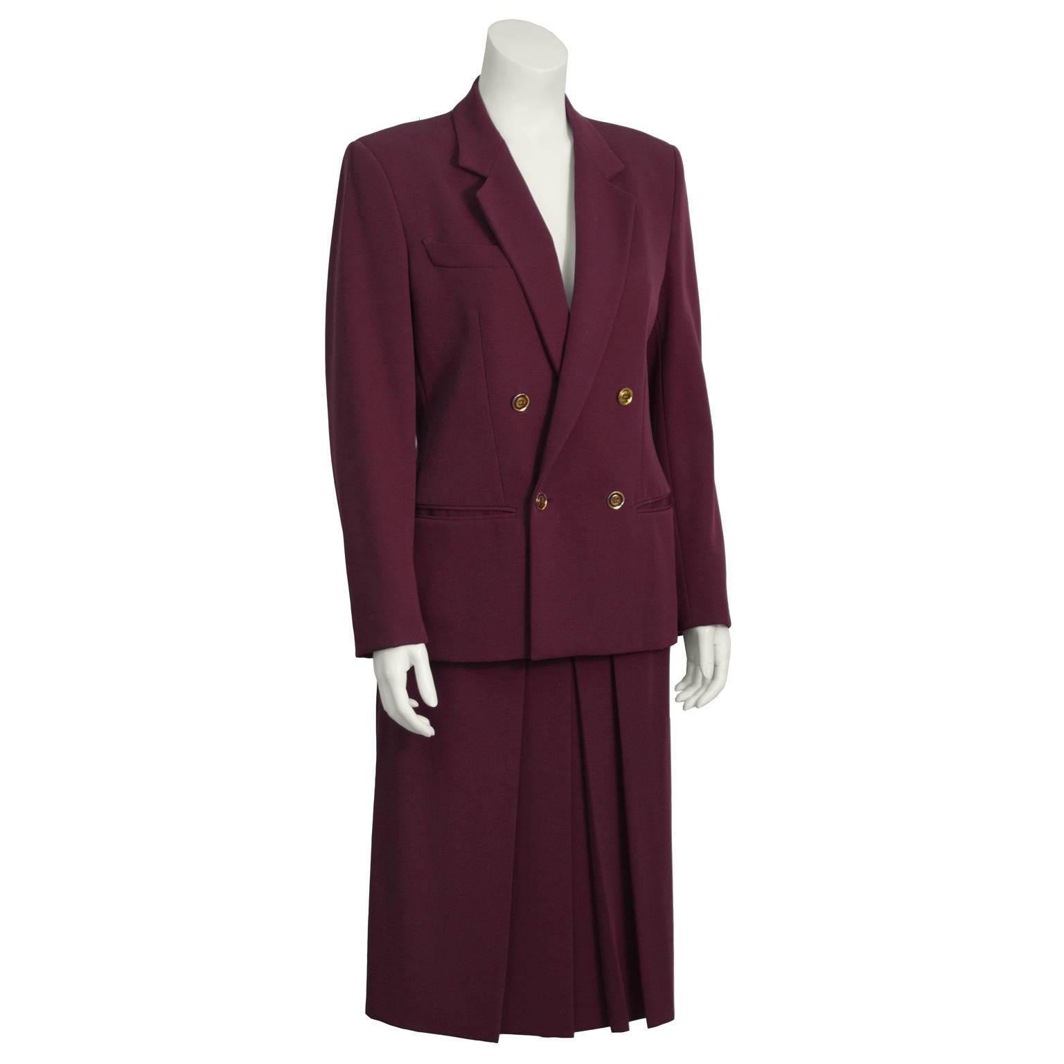 This fabulous Gucci bodeau gabardine skirt suit dates from the 1970's. Double-breasted jacket features notched lapels, a flap pocket on right breast, and two slit pockets at the hips. Box pleated knee-length skirt has four gold buttons on the front.