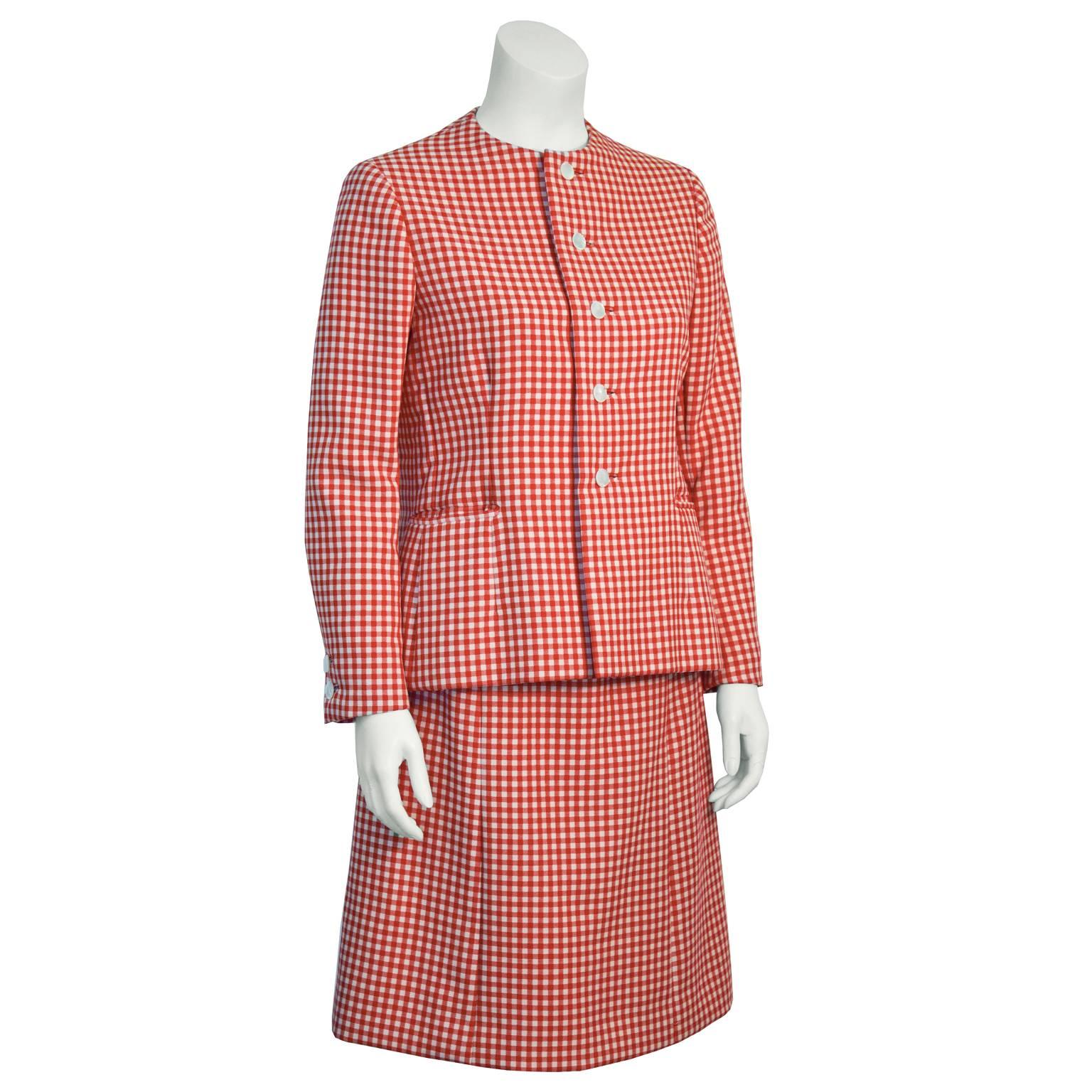 Adorable Norrell red and white gingham skirt suit from the 1960's. Collarless jacket has two patch pockets at the hips. Hips have slight flare, to create a more feminine silhouette. Front button closure with white buttons. Sleeves have two white