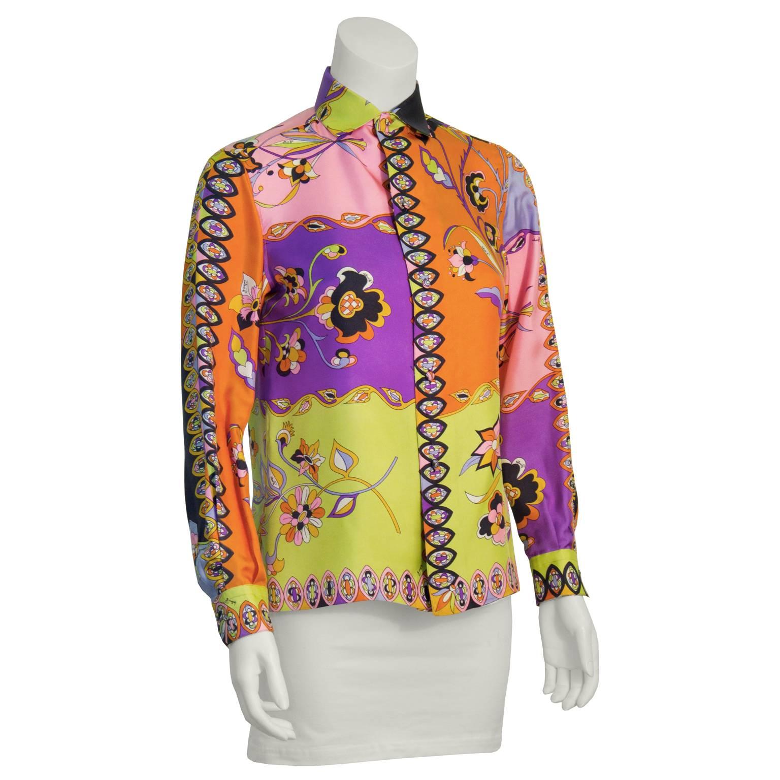 Wunderschöne, mehrfarbige Seidenbluse von Emilio Pucci aus den 1960er-Jahren mit hochgeknöpftem Kragen, Knopfdetails an den Manschetten und einem Allover-Print aus verschiedenen Blumenmustern. Das Muster enthält Noten von Orange, Lila, Rosa,