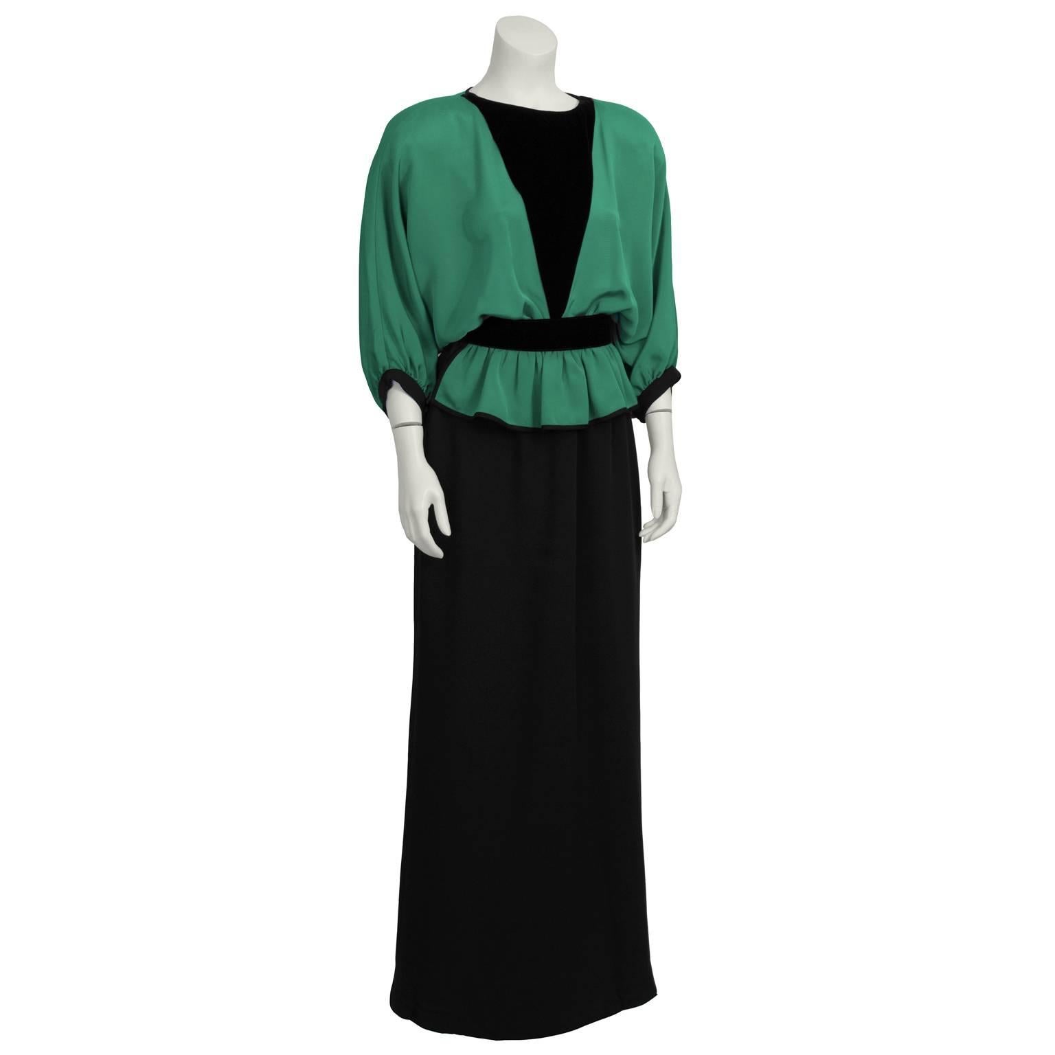 Fabulous green silk crepe and velvet black gown from Valentino from the 1990's features a  loose-fitting, green, bat wing sleeved bodice with a deep black velvet V in the center. Waist is cinched with gathering. Straight cut black skirt. Back single