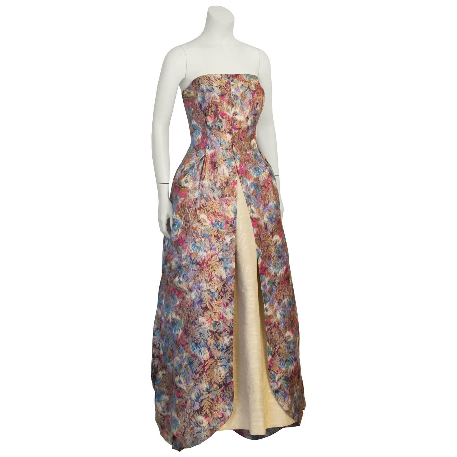 Gorgeous anonymous 1950's strapless brocade floral gown purchased in Paris comes in a stunning princess cut, with a split front opening and slightly balloon gathered over skirt,  with a cream silk underskirt. Floral brocade design in pink, orange,