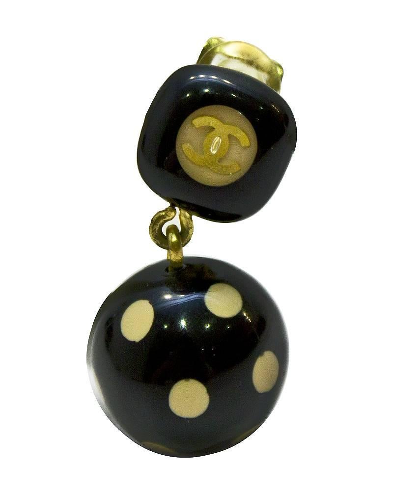 Chanel black and beige clip on style earrings from Fall 2005 collection. The black plastic earrings have a gold CC in a beige circle at the top and a drop with a black ball with beige dots. In excellent condition.

Drop: 1.25
Width at top: 0.5