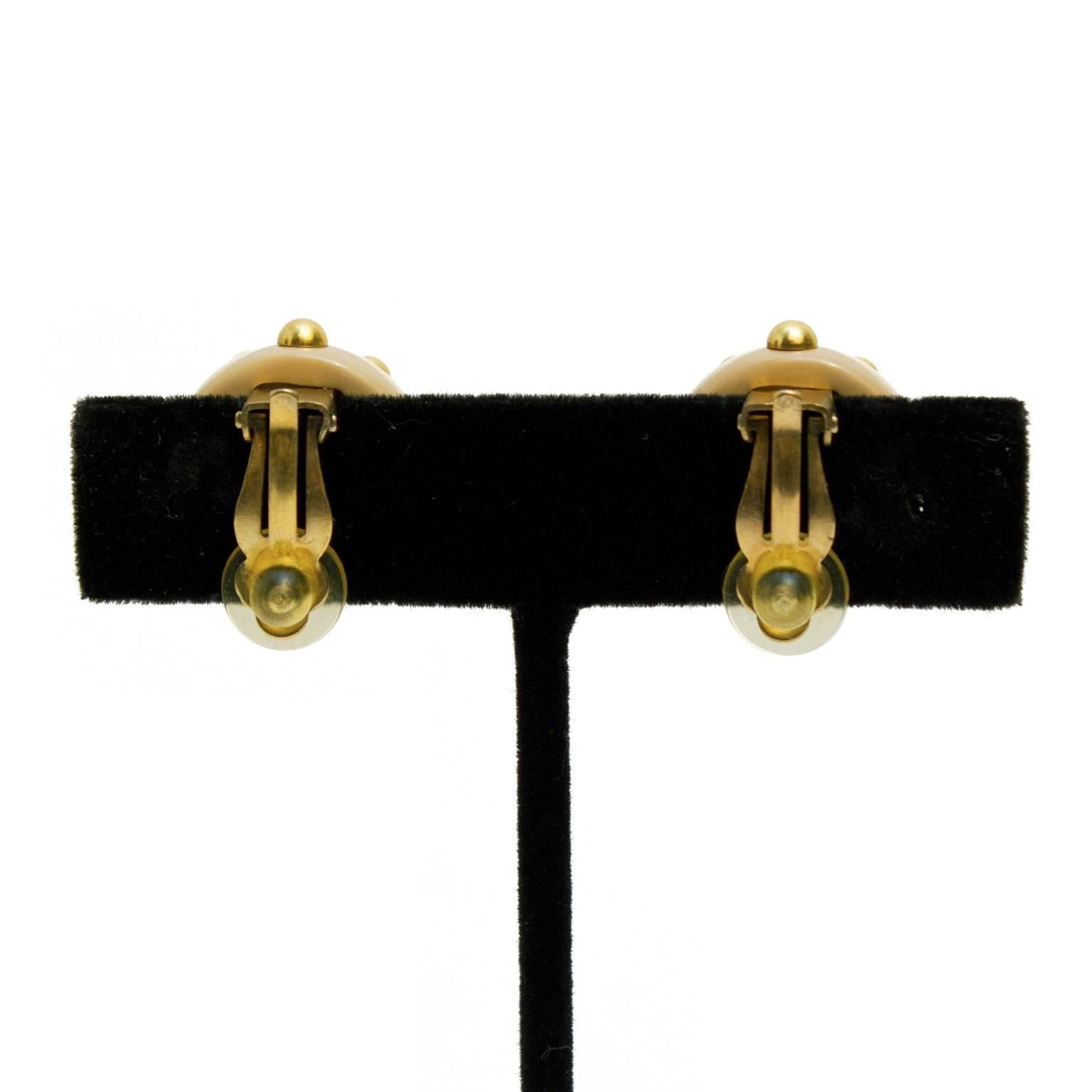 These Chanel clip-on earrings from the Autumn 2000 collection are beige resin with gold tone studs, and a small CC logo in the center. Stamped with Chanel A 00 on the back. Excellent vintage condition.

