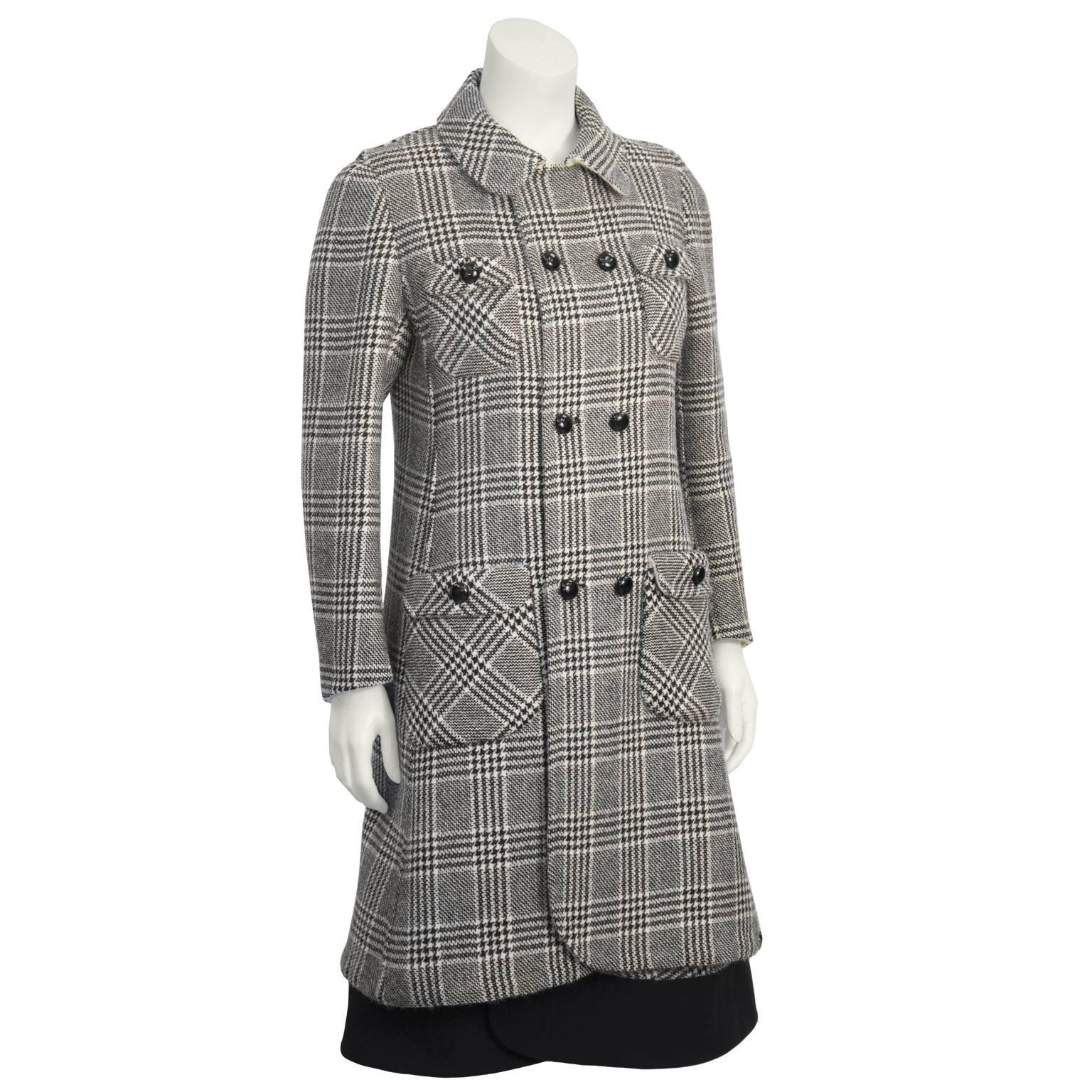 This uber chic Italian black and white hounds tooth ensemble dates from the 1960's. 7/8th length A-line coat is collared and double breasted. Four patch pockets detailed with a single black button.  Sleeveless dress has four faux flap pockets on