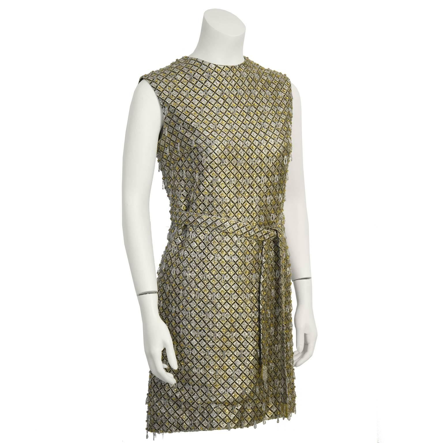 Fabuleuse mini robe anonyme à paillettes et perles dorées et argentées datant des années 1960. Coupe A-line avec un col haut et une ceinture optionnelle de la même matière. Fermeture à glissière dans le dos. Excellent état vintage. S'adapte comme un