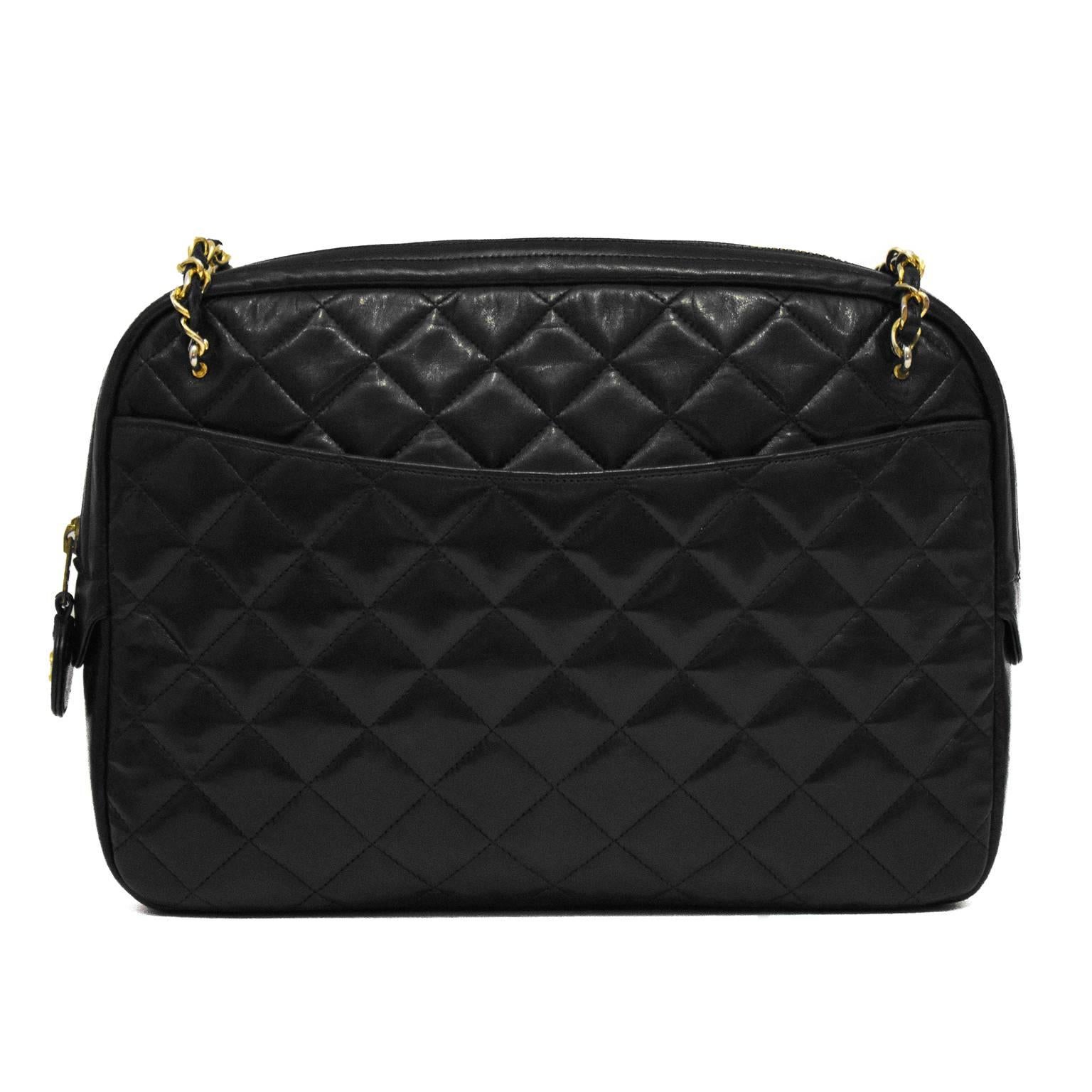 La clásica bolsa Chanel negra para cámara de los años 80 está fabricada con piel de cordero acolchada negra, y cuenta con un bolsillo grande a cada lado y un cierre superior con cremallera. Las correas de cadena tienen hombreras de cuero. Herrajes