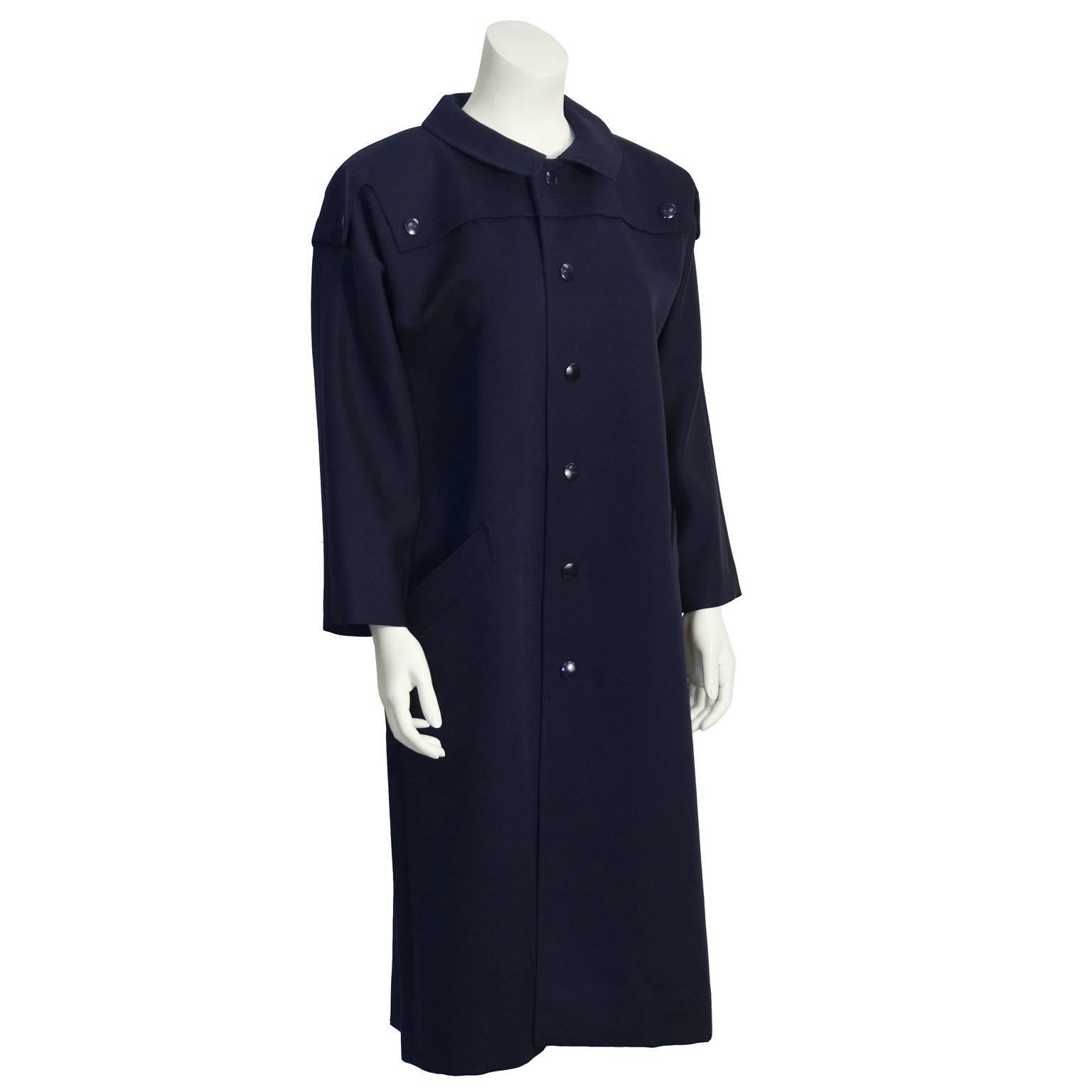 This Pierre Cardin trench coat from the 1970's features a Peter Pan style rounded collar, a storm flap attached with buttons, front button closure and two broad welt side pockets. Snap buttons are navy plastic. Excellent vintage condition. Fits like