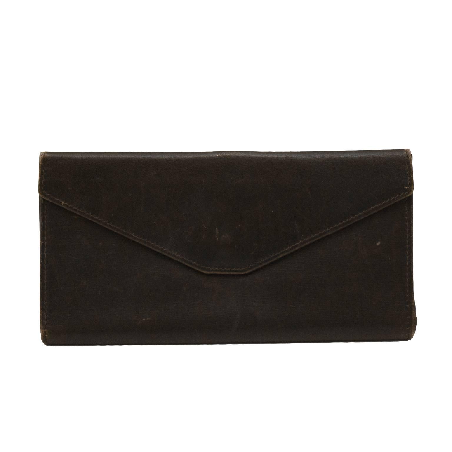 This classic unisex Gucci long bi-fold wallet from the 1970's is brown leather with a fabulous gold tone metal belt buckle closure. Features envelope flap exterior pocket, and green leather interior lining. Four large interior pockets make for great