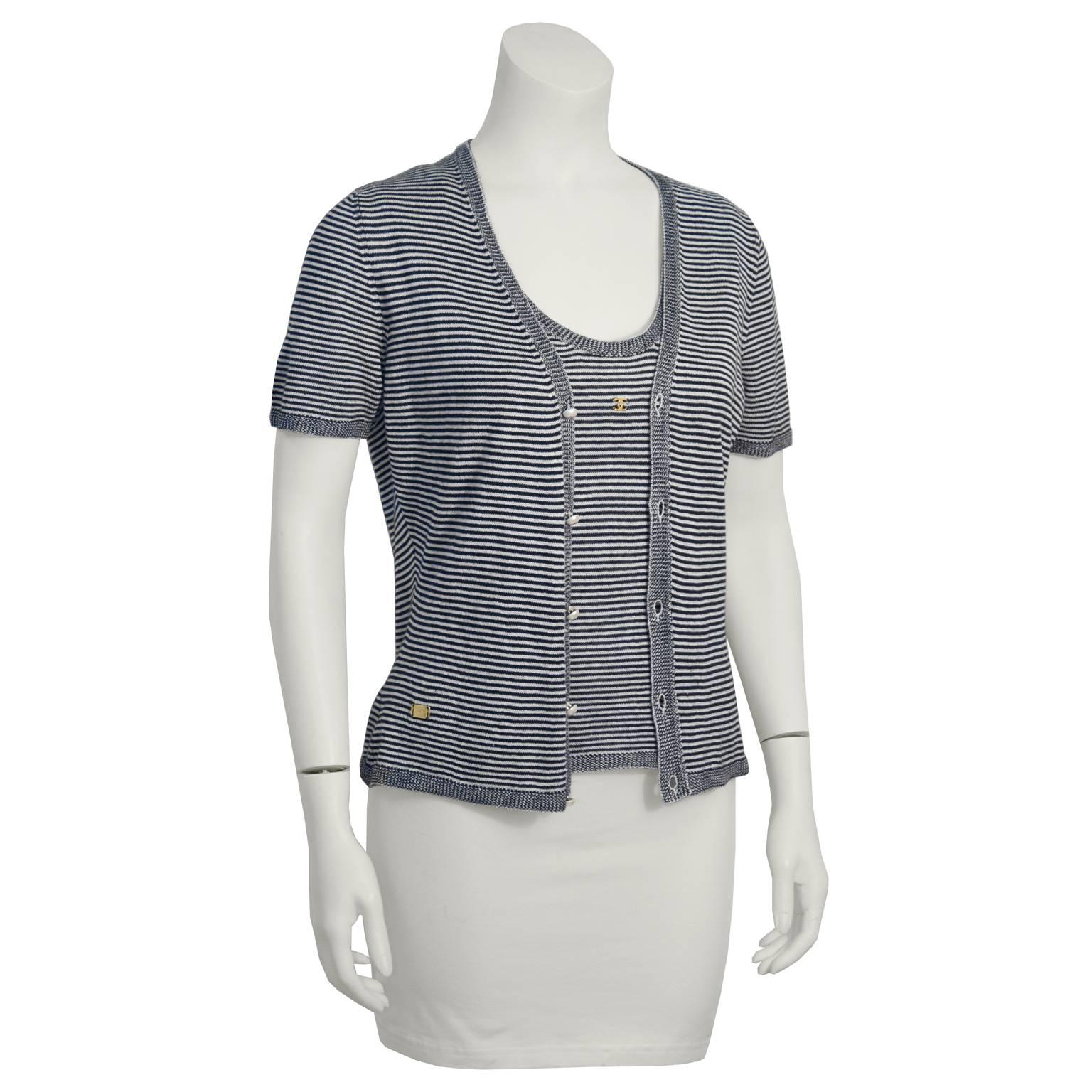 Casual chic 1990's Chanel striped knit twin set in navy and white. Tank top has a small gold CC on the chest.  Short sleeved cardigan has a front button closure and a small gold Chanel tag on the hip. Pearl buttons have gold CC logo on them.