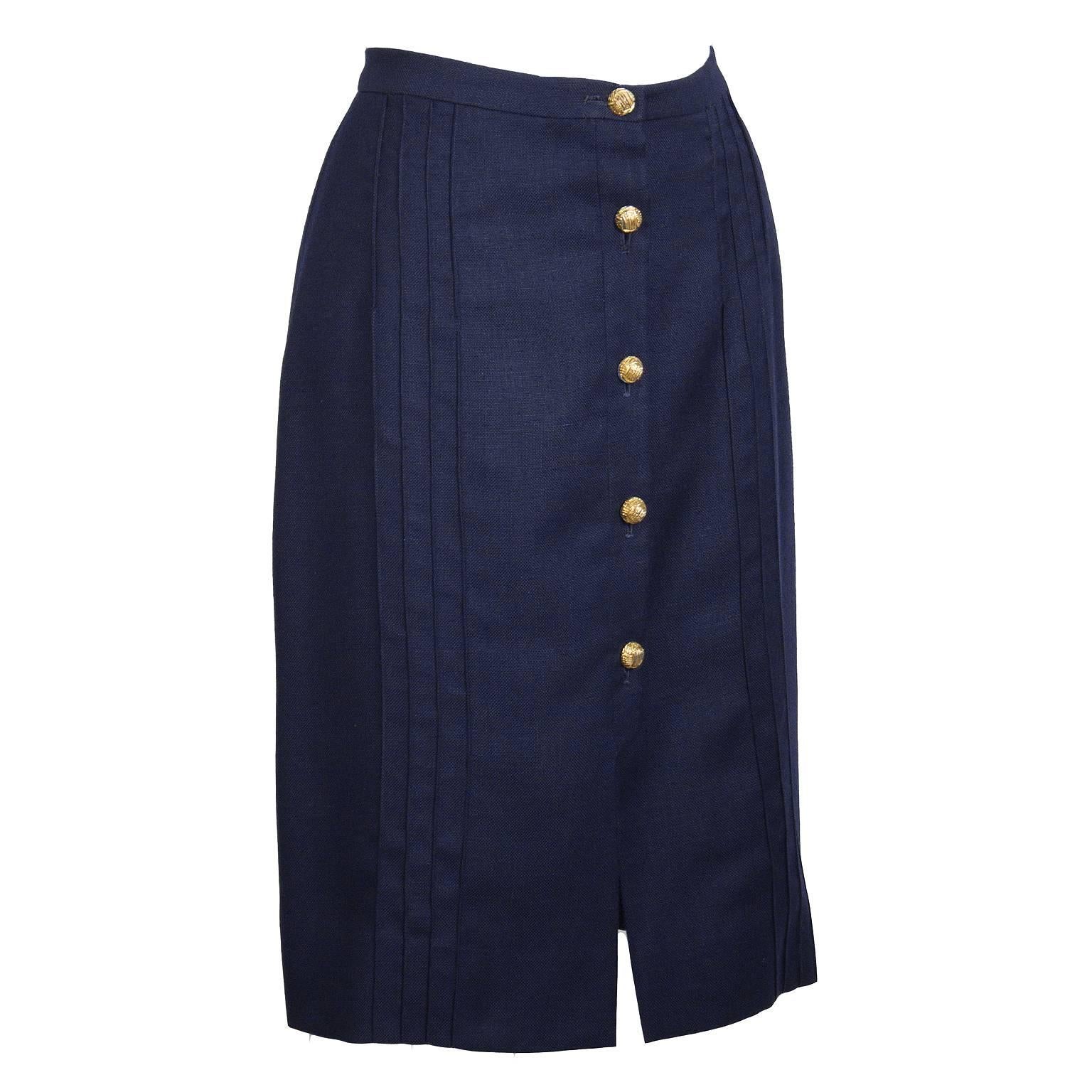 Simple and sophisticated Valentino blue linen skirt from the 1970's. Straight cut, with a front button closure and a front slit. Buttons are gold with a woven motif. Interesting vertical seaming detail on front and back. Excellent vintage condition.